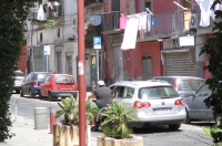Skuterzysta trzyma się drzwi auta. Typowy sposób jazdy na pd. Włoch.
